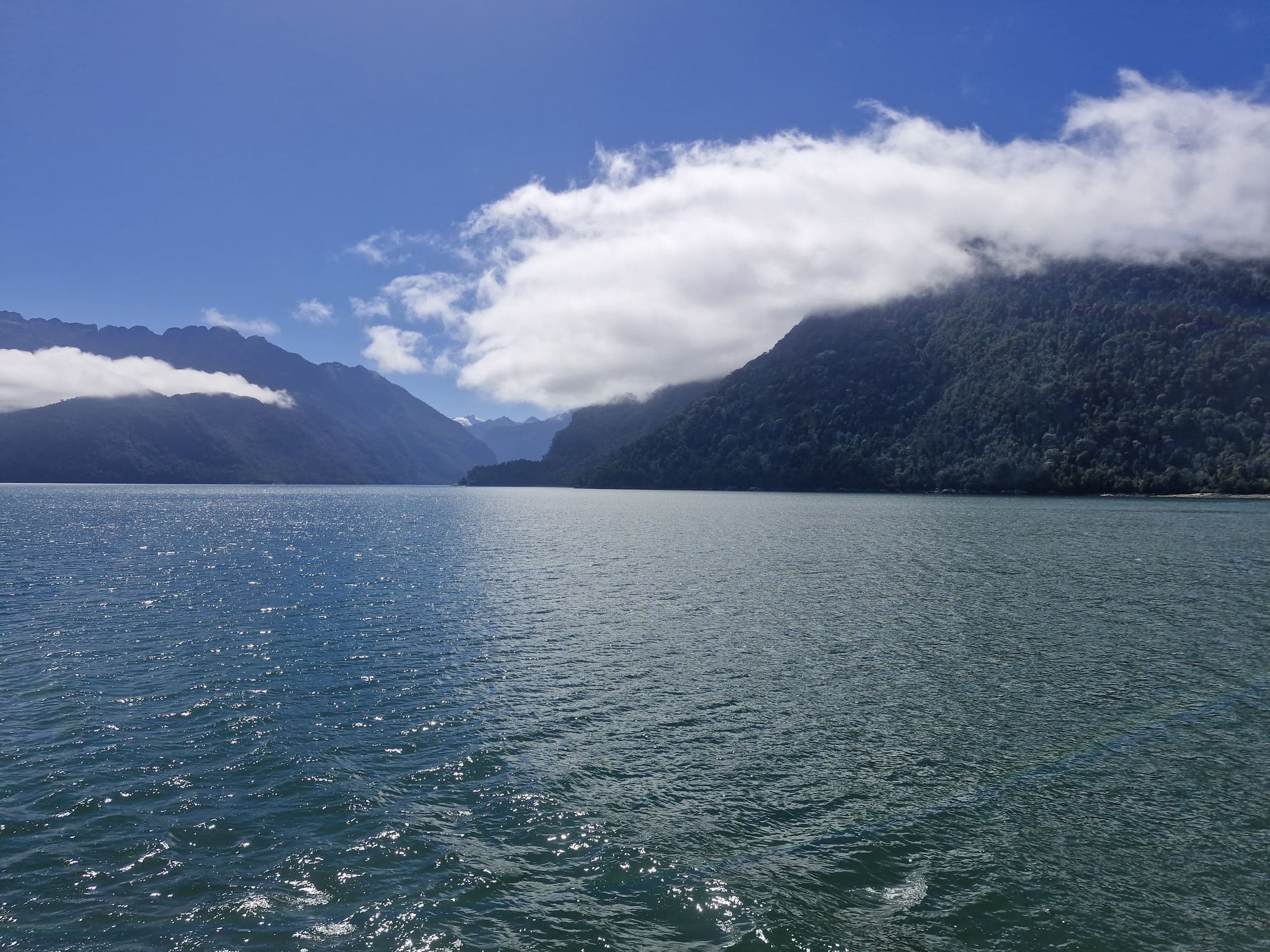 lago con una nube posada sobre el cerro