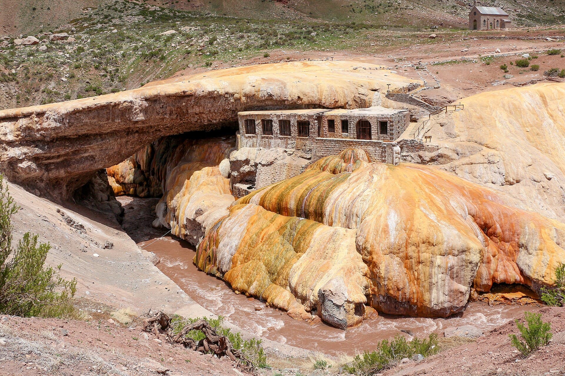El arco naranjo del Puente del Inca sobre el río